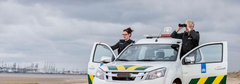 Twee douanebeambten met auto